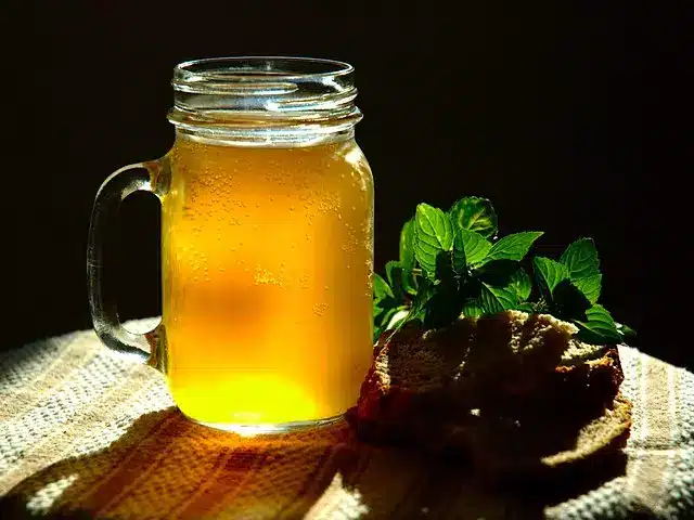 Kvass de menta caseiro. Mostrado com pão de centeio e folhas de hortelã.
