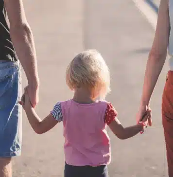 Casal de pais segurano as mãos da filha