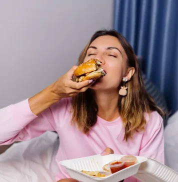 Mulher comendo hamburger